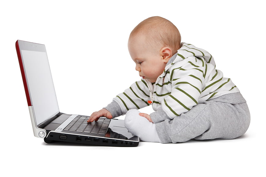 Baby Boy Sitting On White Background Using Laptop Computer