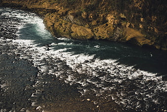 Aerial View of Turbulent River Flowing Through Rocky Canyon