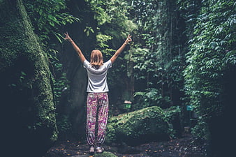 Woman with Arms Raised in Lush Jungle Forest