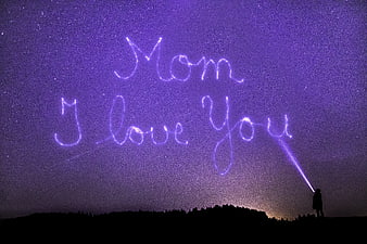Person Writing Mom I Love You in Stars with Flashlight