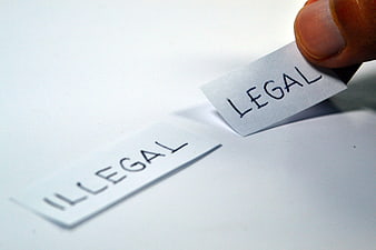 Hand placing legal label over illegal note