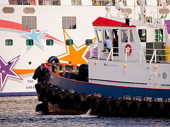 Tugboat Tampa assisting large cruise ship in port