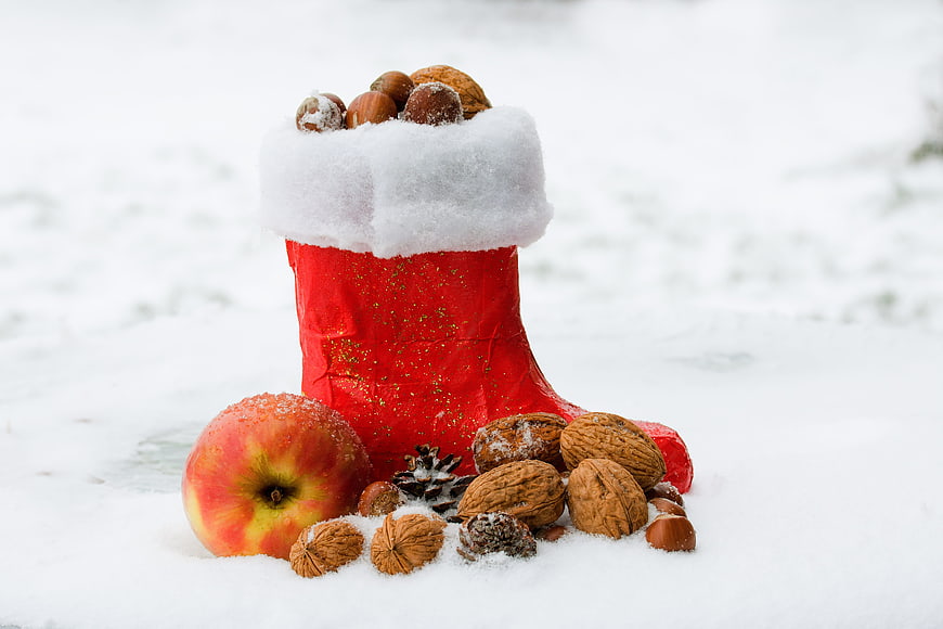 Red Christmas Boot Filled with Nuts and Apple in Snow