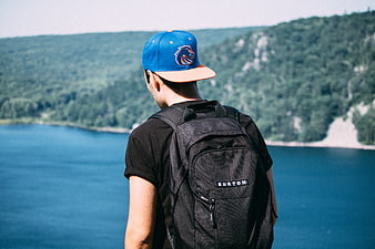 Man with backpack looking at lake and mountains