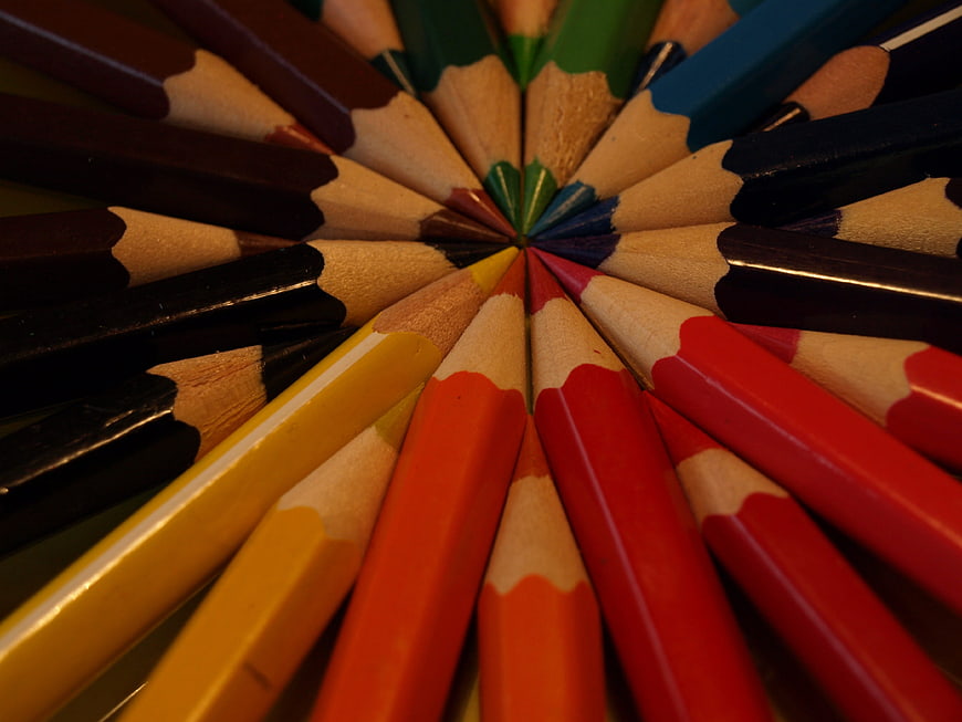 Colorful wooden pencils arranged in a circular pattern