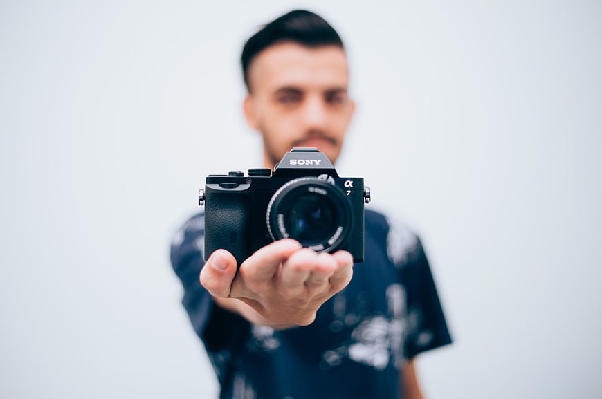 Man Holding Black Sony Camera Towards Viewer