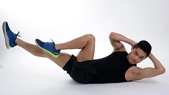 Man doing bicycle crunches exercise on white background