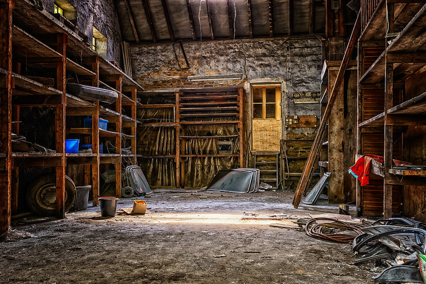 Interior of an Abandoned Workshop with Rusty Shelves and Debris