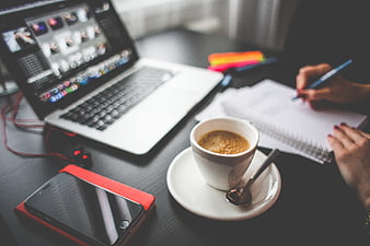 Creative workspace with laptop, coffee, and notebook