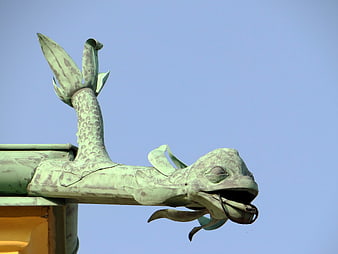 Green patina dragon roof ornament against blue sky