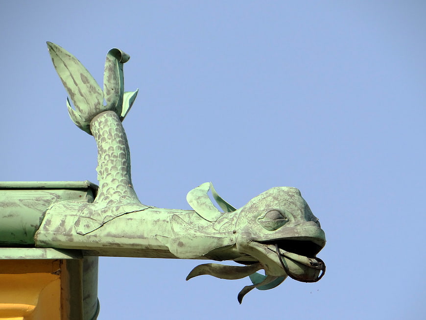 Green patina dragon roof ornament against blue sky