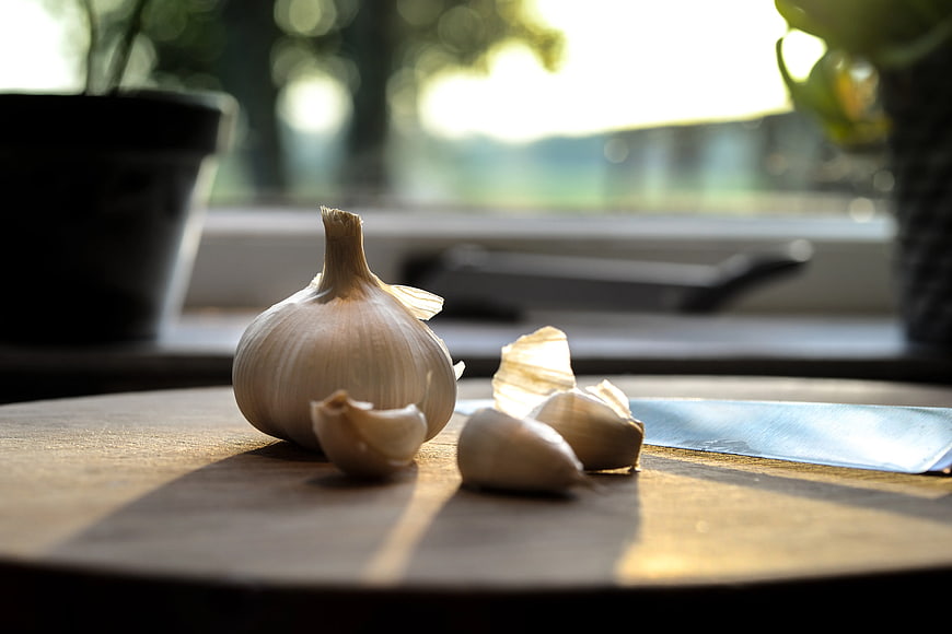 Fresh Garlic Bulb and Cloves on Wooden Cutting Board