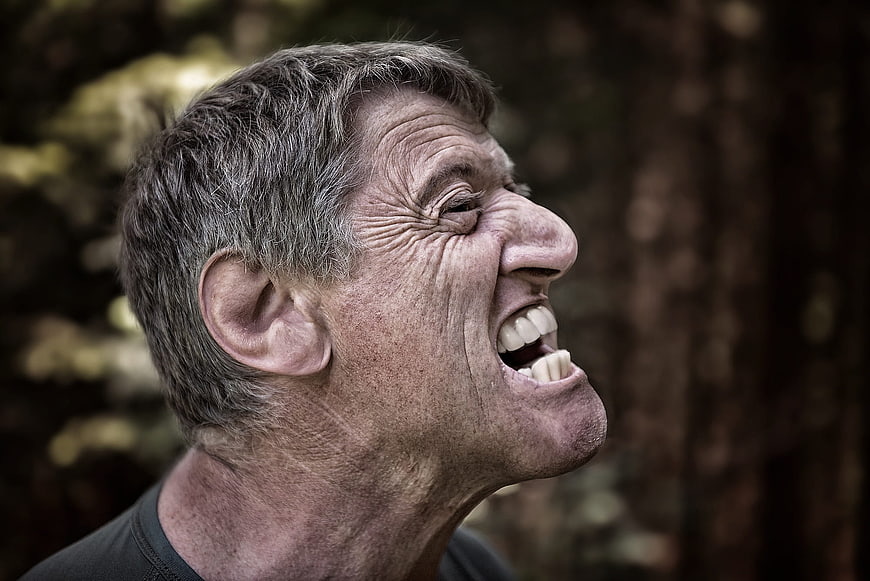 Close-up portrait of laughing senior man outdoors