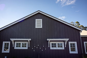 Modern Dark House Exterior with White Trim and Blue Sky