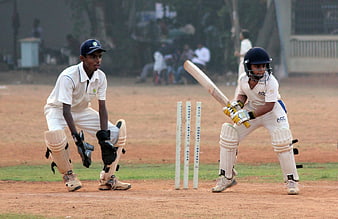 Cricket Match Action: Batsman and Wicketkeeper on the Pitch