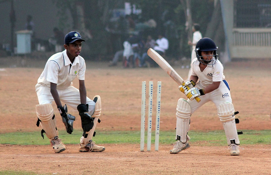 Cricket Match Action: Batsman and Wicketkeeper on the Pitch