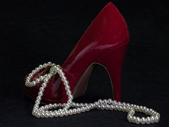 Red Patent High Heel Shoe With Pearl Necklace On Black Background