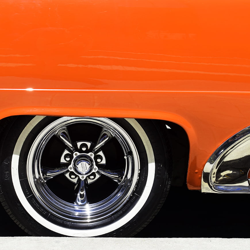 Close-up of Orange Classic Car Wheel with Chrome Rim