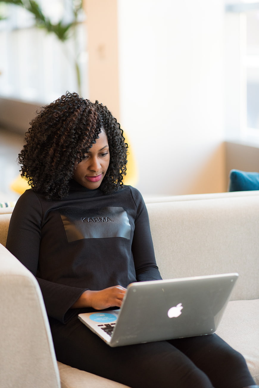 African American Woman Working on Laptop on Couch