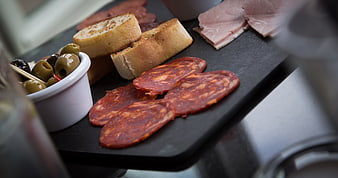 Gourmet charcuterie board with salami, ham, bread, and olives