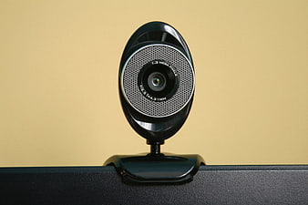 Black Webcam Mounted On Monitor Against Yellow Background