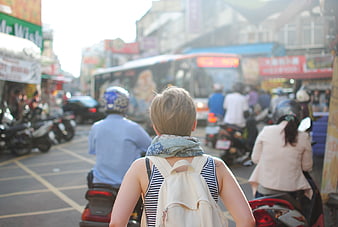 Woman with Backpack Walking in Busy Asian Street Traffic