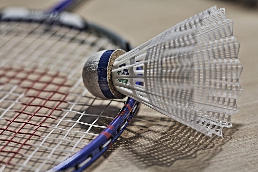 Close-up of a badminton shuttlecock resting on a racket
