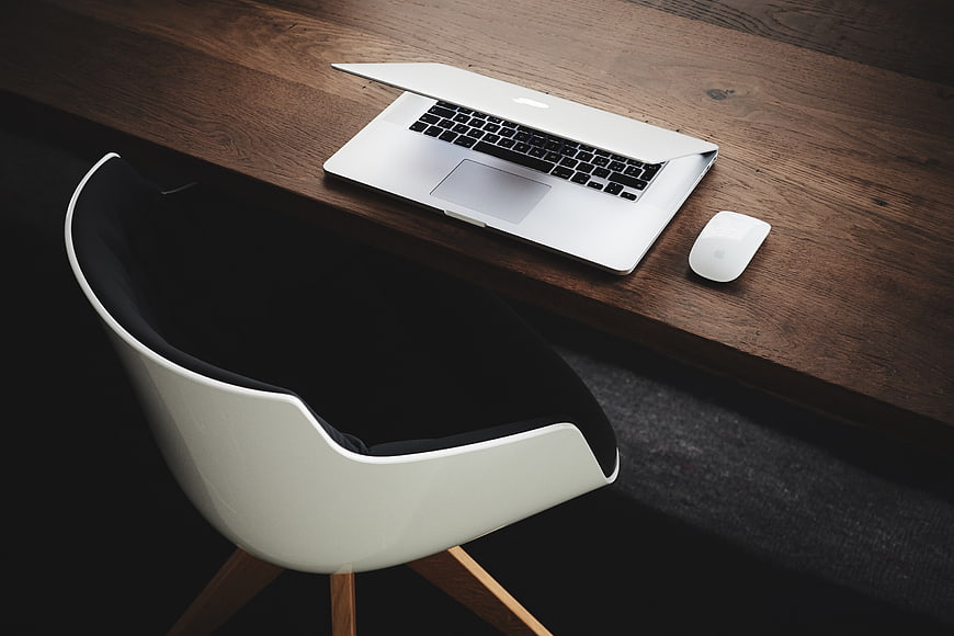 Modern Workspace with Laptop and Chair on Wooden Desk