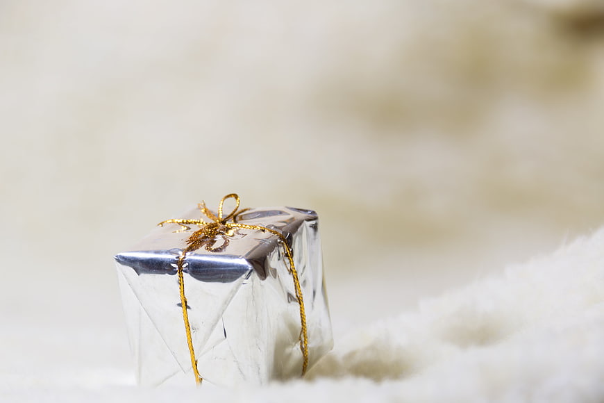 Silver Gift Box With Gold Ribbon On White Fur Background