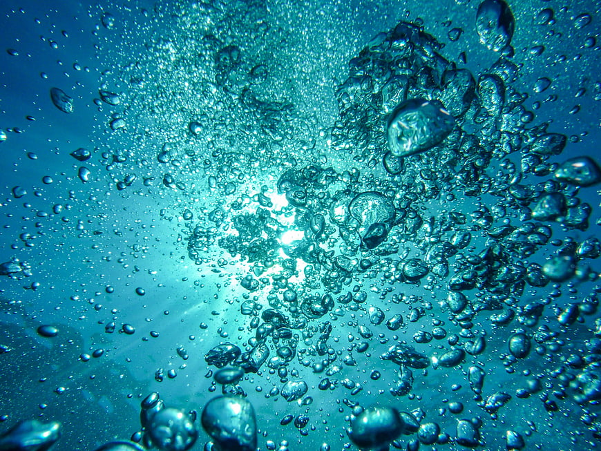 Underwater Air Bubbles Rising in Blue Ocean Water