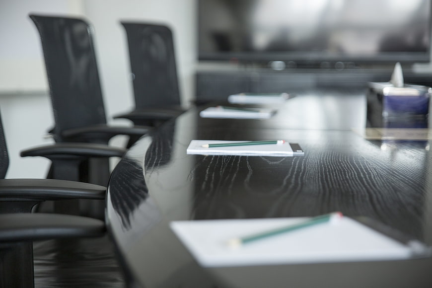 Modern conference room with notepads and pencils on table