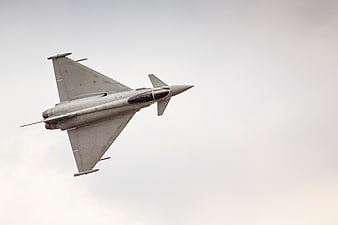 Gray Military Fighter Jet Flying Against Overcast Sky
