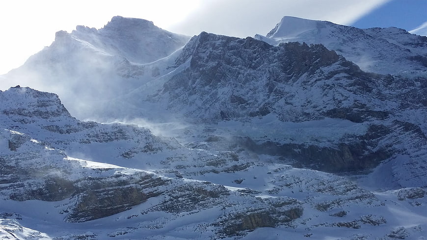Snowy Swiss Alps mountain landscape with wind and clouds