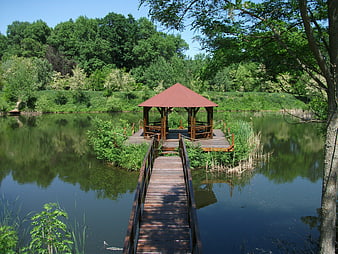 Wooden gazebo on a lake with a bridge