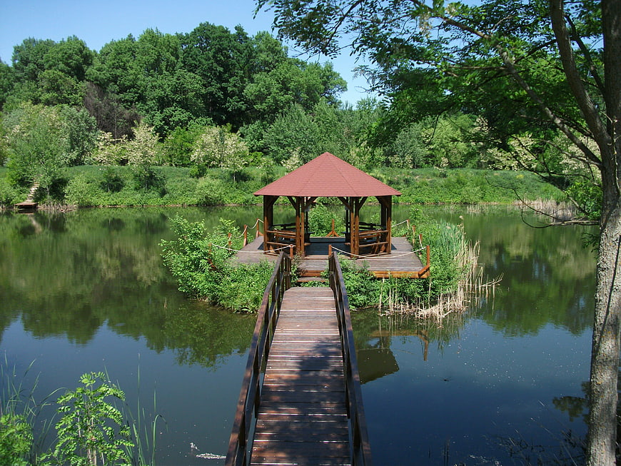 Wooden gazebo on a lake with a bridge