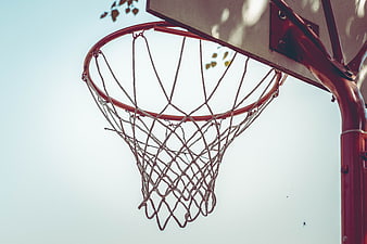 Close-up of a basketball hoop net against a bright sky