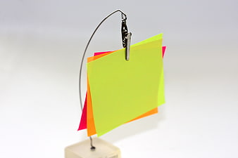 Colorful sticky notes clipped to a metal stand on white background
