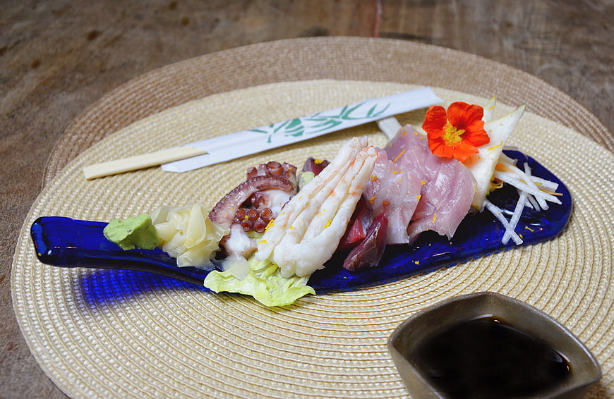 Assorted sashimi platter with octopus and fish on blue plate