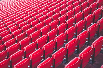 Rows of empty red stadium seats in a sports arena