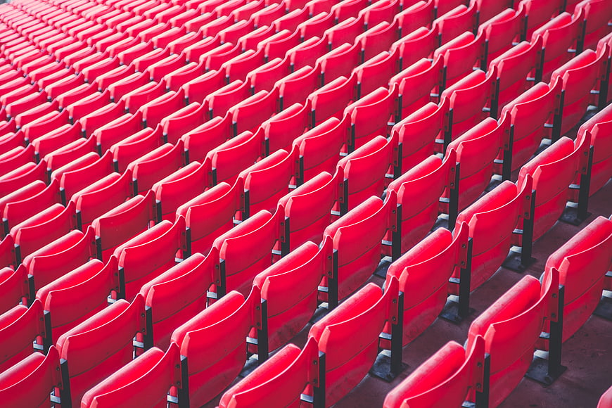 Rows of empty red stadium seats in a sports arena