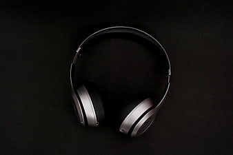Silver and black over-ear headphones on dark background
