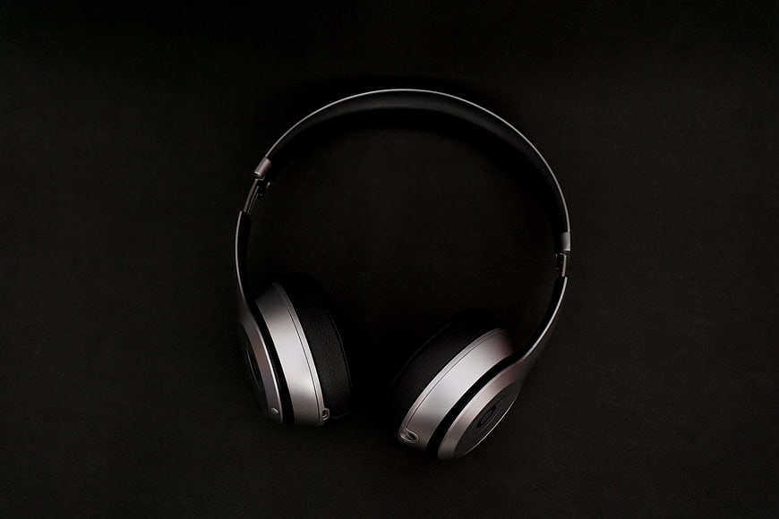 Silver and black over-ear headphones on dark background