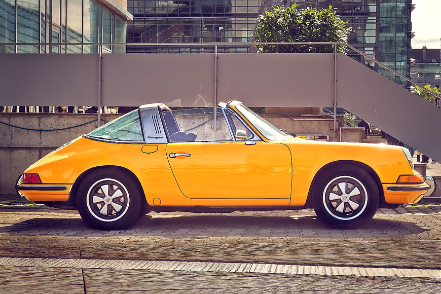 Side Profile Of A Yellow Vintage Porsche 911 Targa Parked On A Street