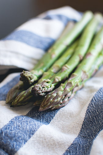 Fresh green asparagus spears on blue striped kitchen towel