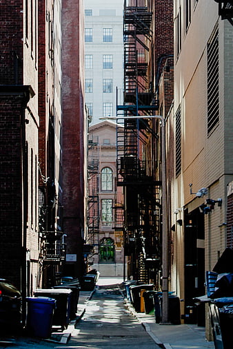 Narrow Urban Alleyway with Fire Escapes and Brick Buildings