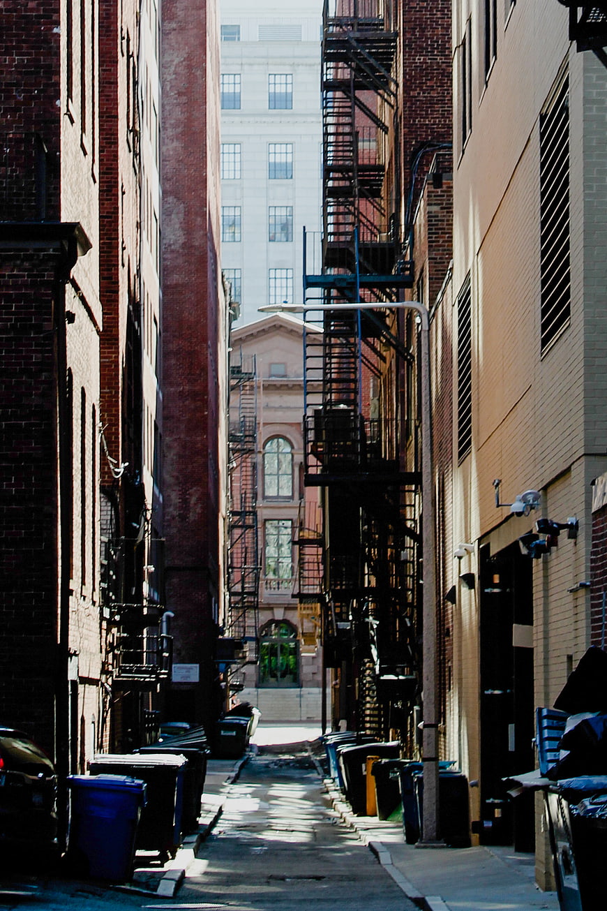 Narrow Urban Alleyway with Fire Escapes and Brick Buildings