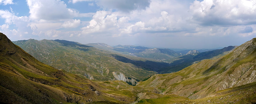Panoramic view of green mountain valley with blue sky