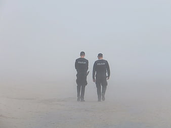 Two Police Officers Walking Away in Thick Fog