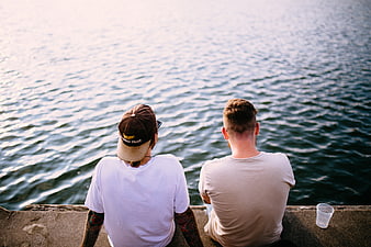 Two Men Sitting by the Sea Looking at the Water