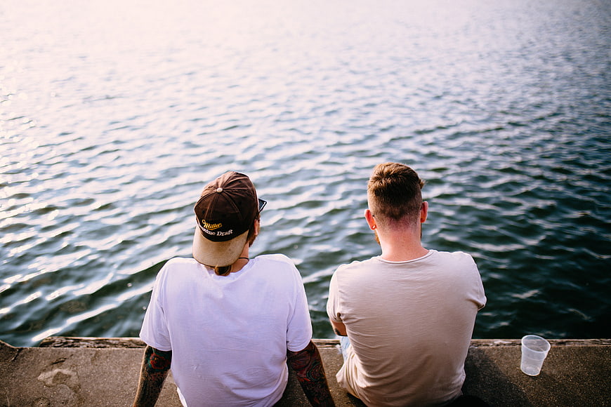 Two Men Sitting by the Sea Looking at the Water